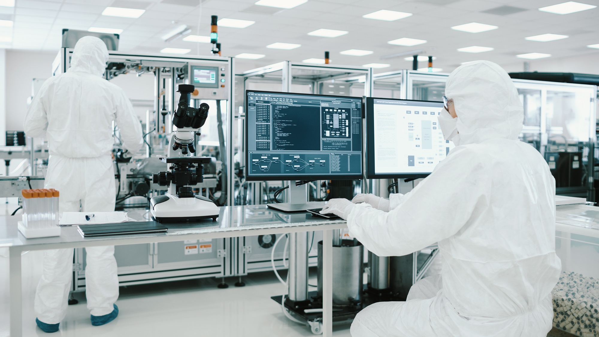 Life sciences professionals in a cleanroom using digital systems for laboratory and manufacturing operations.